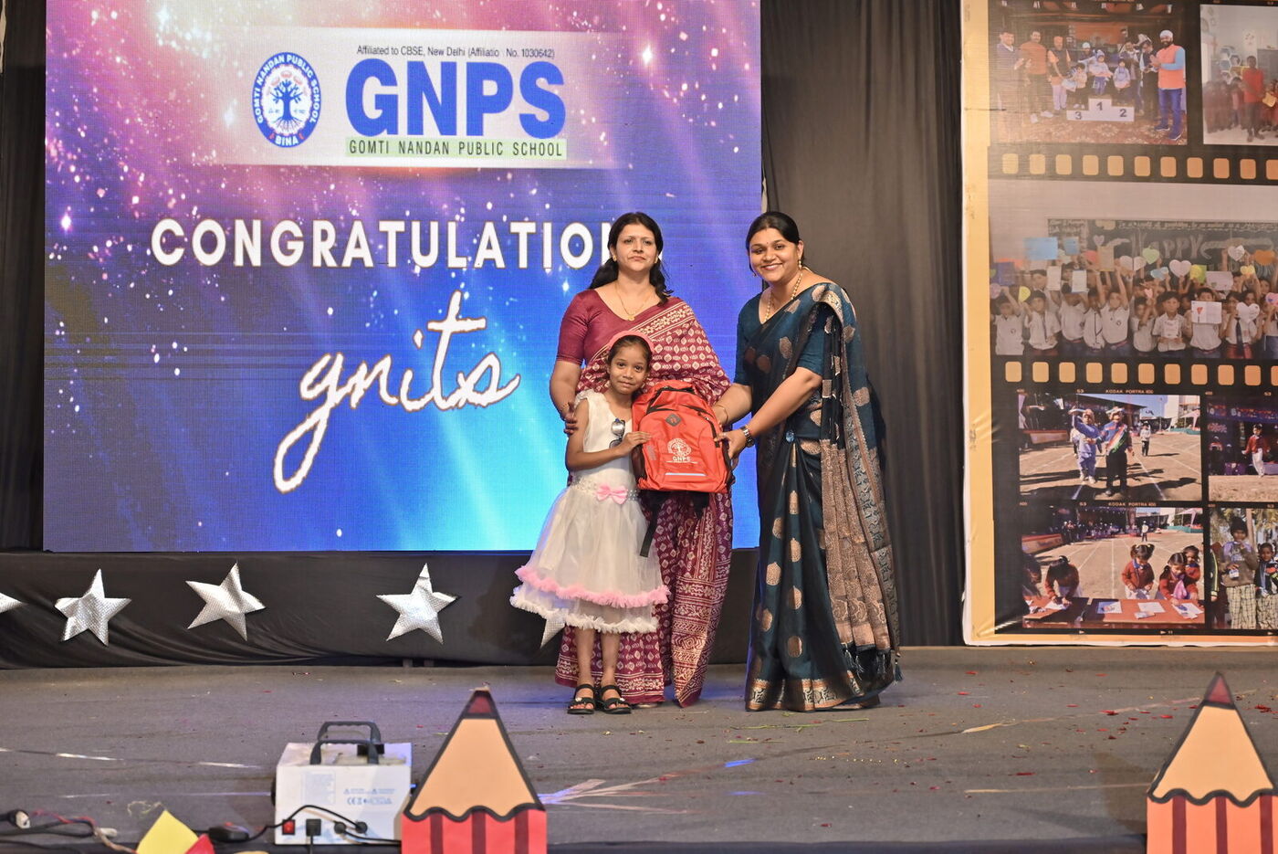 A kindergarten graduate receives her certificate on stage at Graduation Day 2026