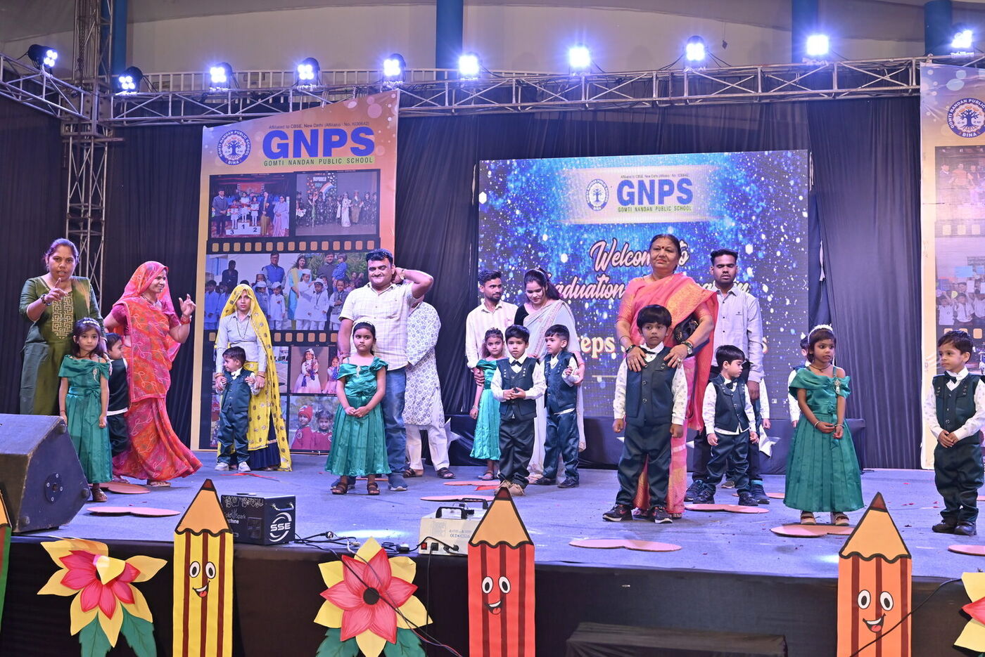 Children in traditional costumes perform on the decorated Graduation Day stage
