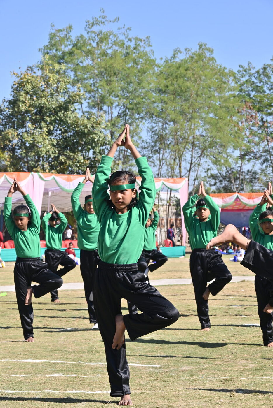 Students in green perform a yoga display on Republic Day