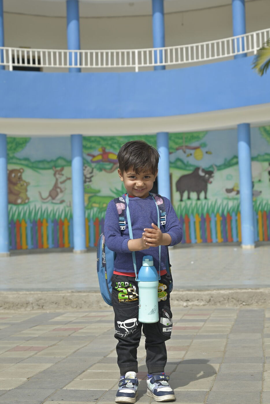 A little one ready for the day in the colourful pre-primary courtyard
